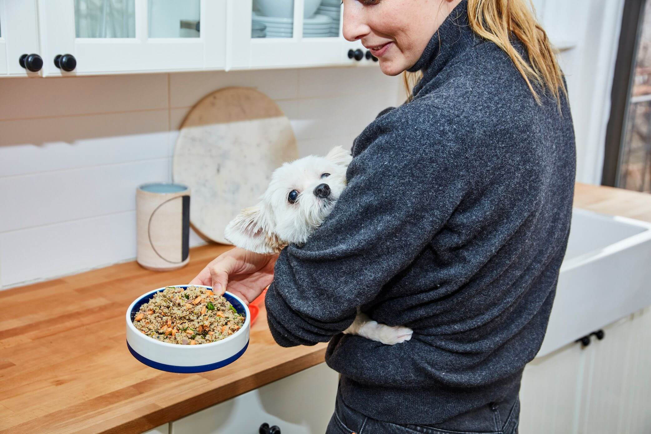 young-woman-feeds-her-small-dog-Ollie-s-fresh-health-food