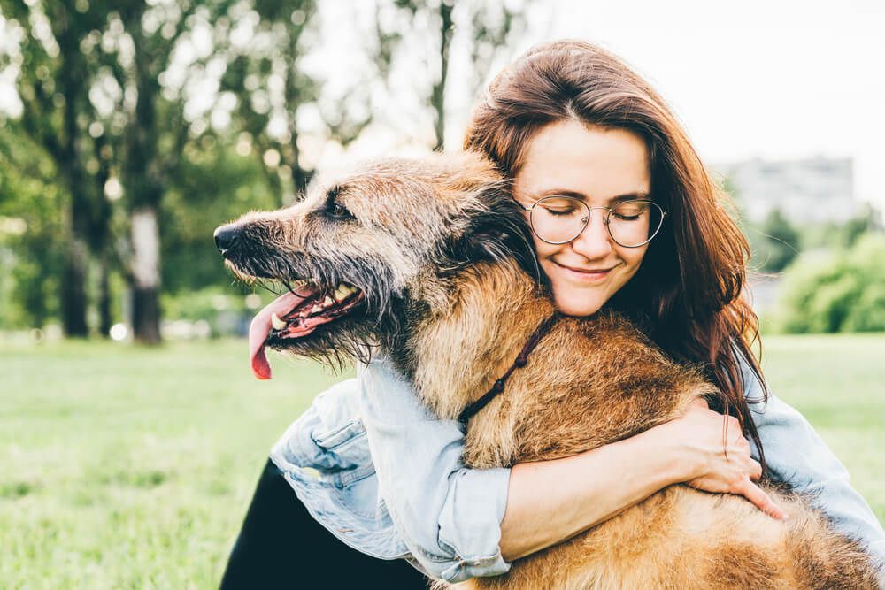 young-woman-embraces-her-aging-dog