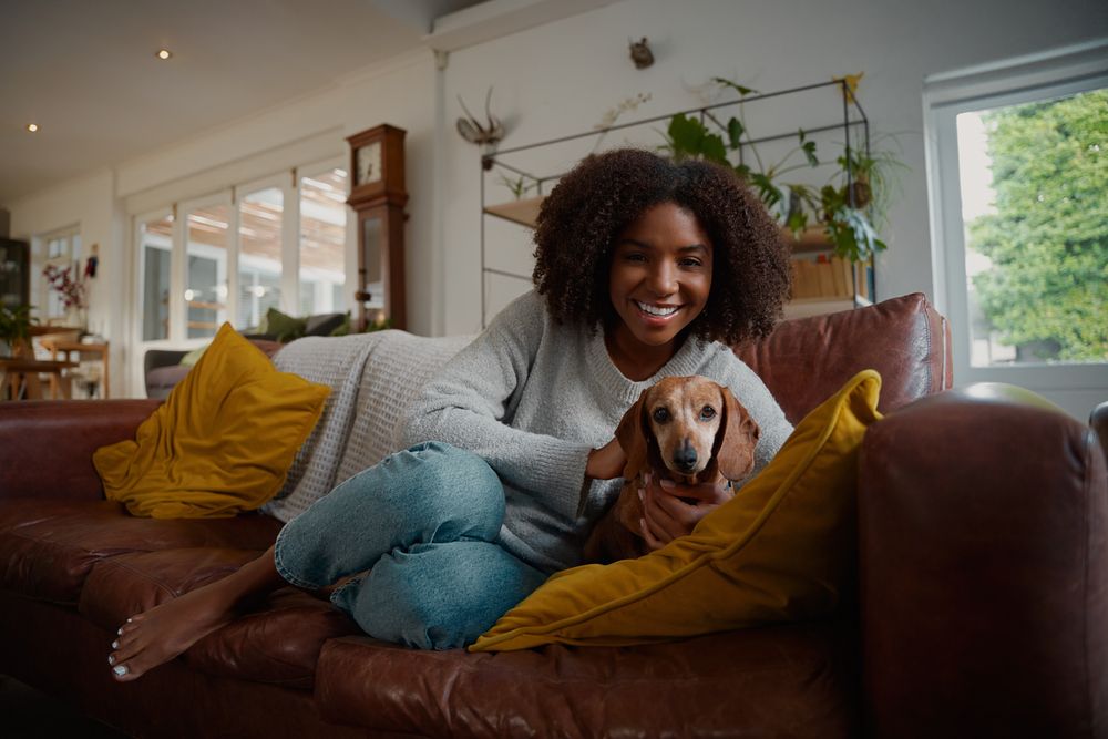 young-woman-gets-cozy-on-couch-with-dog