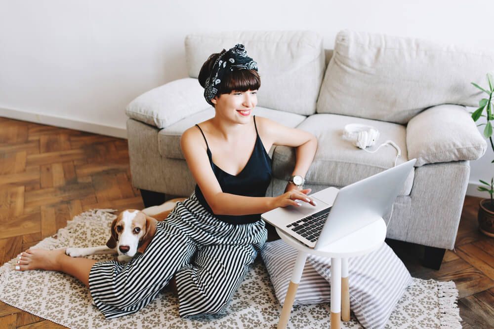 stylish-young-woman-takes-classes-at-home-with-her-dog