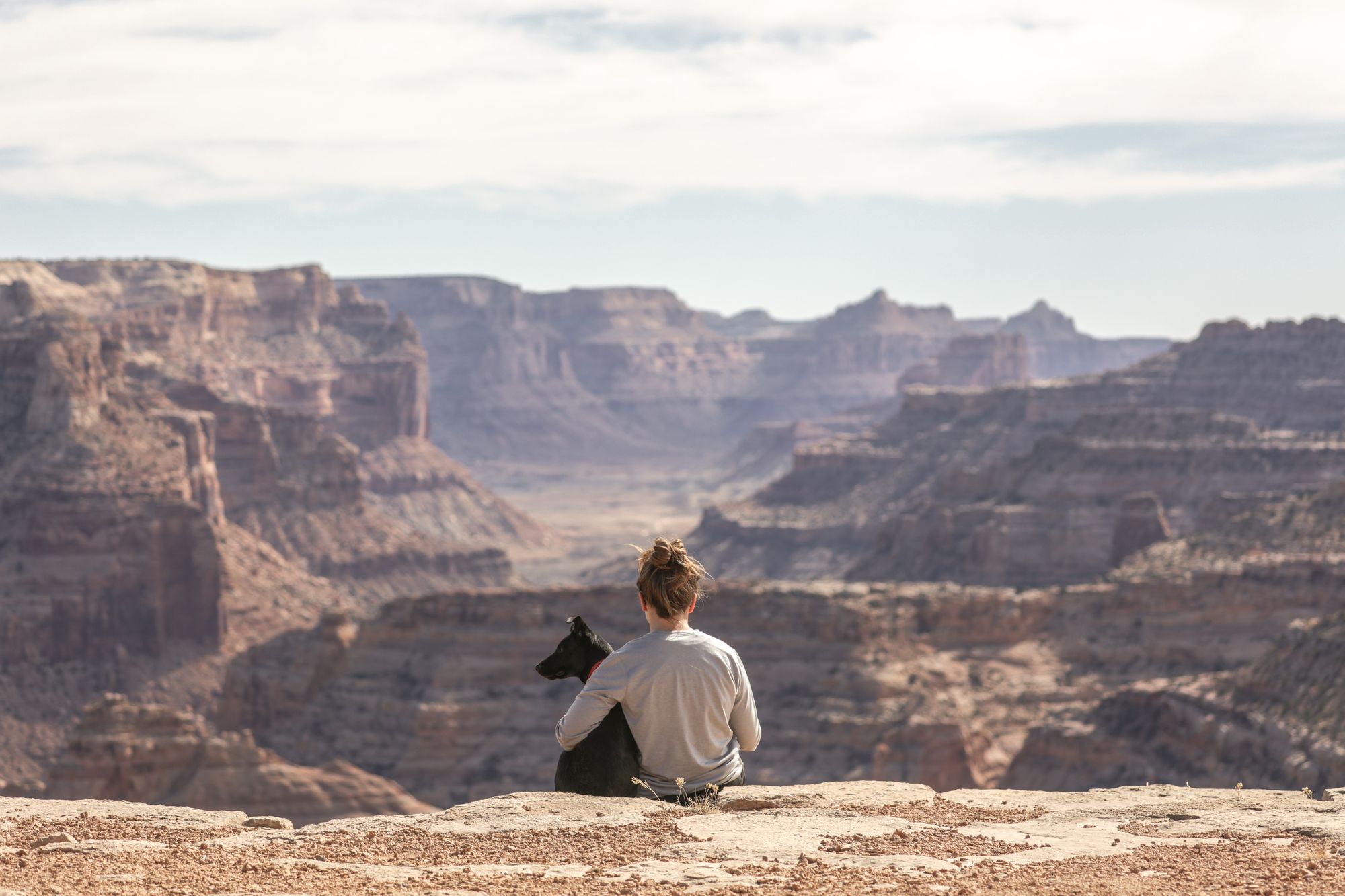 woman-with-dog-ad-the-edge-of-a-canyon-in-utah